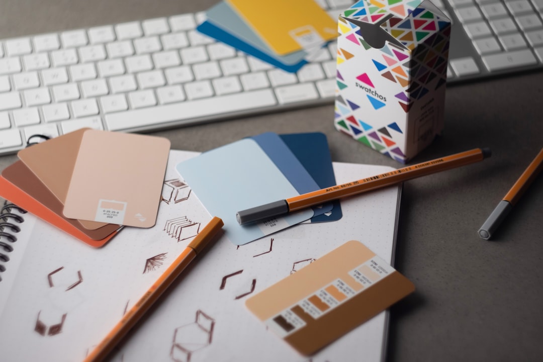 services-03 Swatchos color swatch cards with CMYK and RGB hex values showing being used by a graphic designer on a graphic designers desk